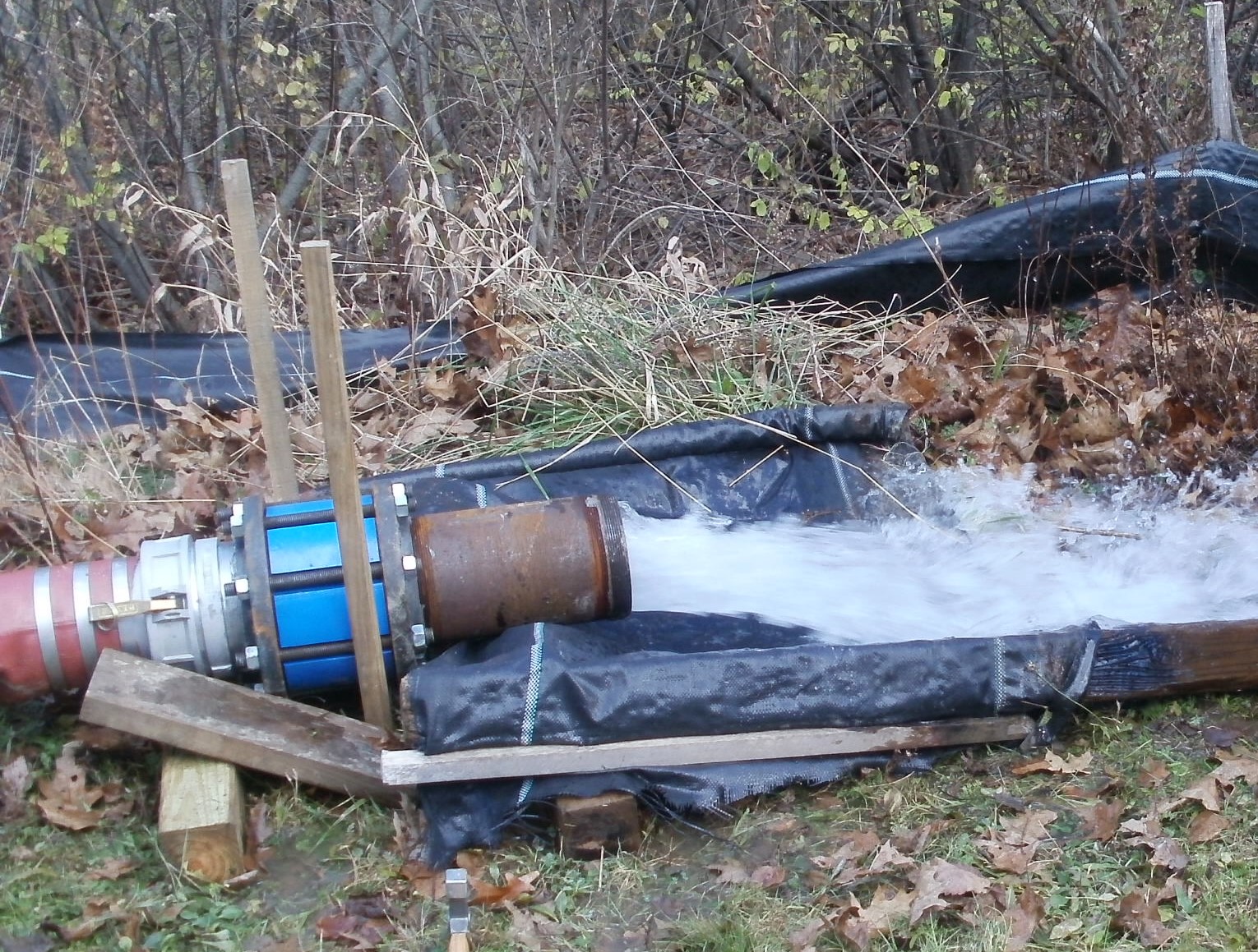 large diameter pipe on the ground with water gushing out of it